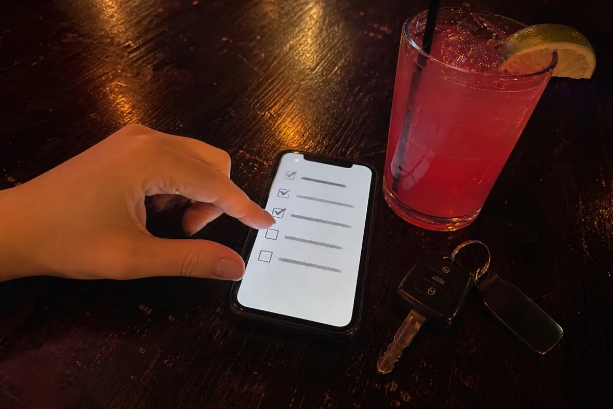 A scavenger hunt checklist on a phone at a bar