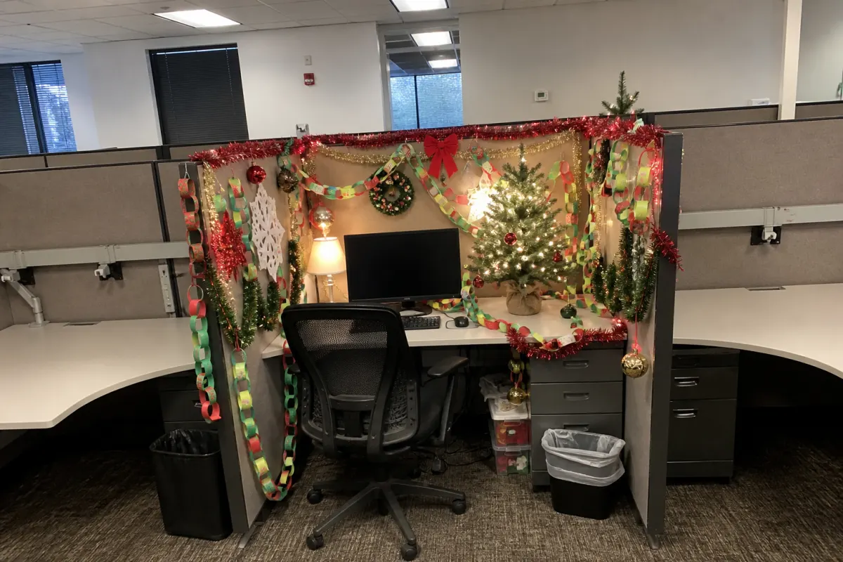 One office desk decorated for Christmas beside two bare ones