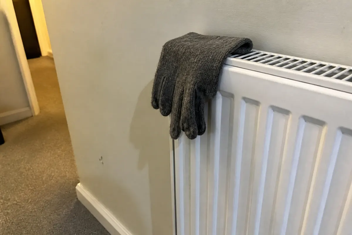 A single glove drying on a radiator